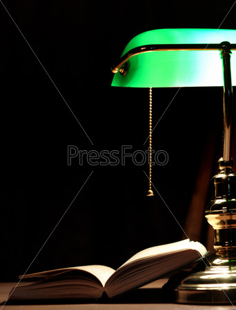 Electric green table lamp and opened book