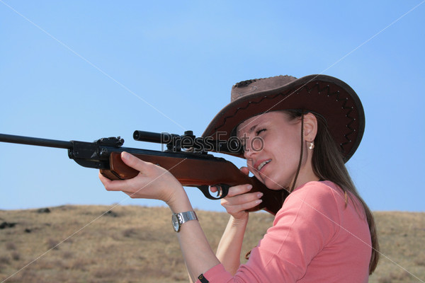 The young  woman with rifle is shooting