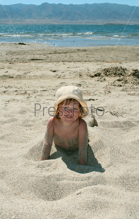 The baby girl plays with a sand