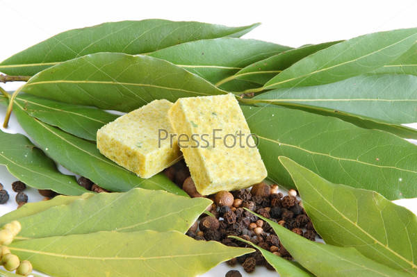 Fresh bay leaves, bouillon cube, whole black pepper and white coriander isolated on white