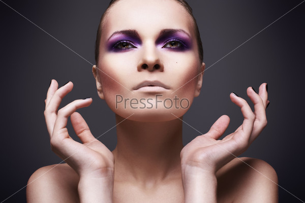 Beautiful woman with colorful violet make-up and black nails