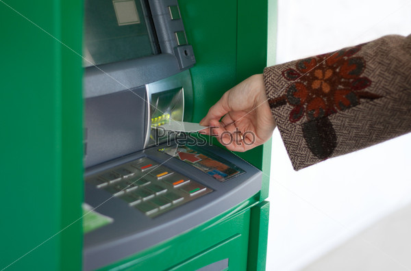 Feminine hand with credit card and green bank terminal