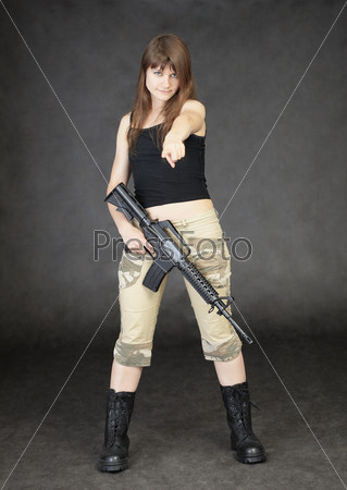 Young woman armed with rifle standing