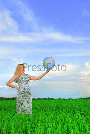 Businessman holding globe blonde in field on green grass holding globe in hand under blue sky(heaven)