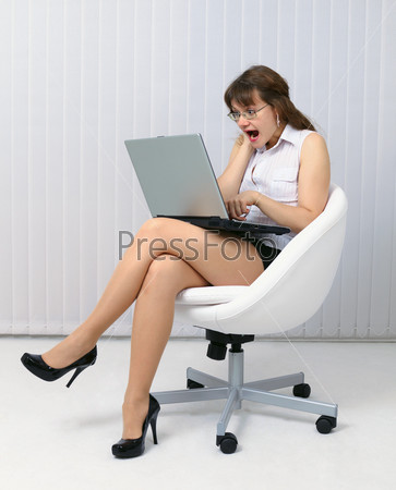 Frightened woman looks at computer screen