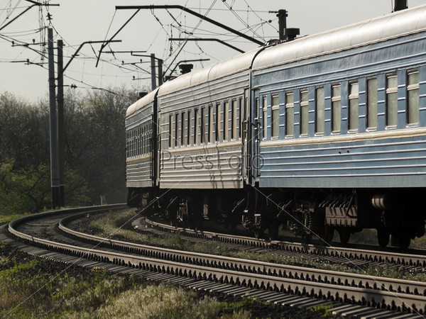 Ukrainian passenger train on curve close-up in evening