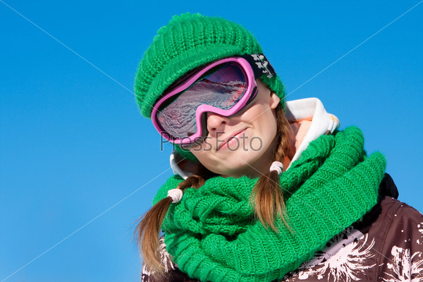Young sporty girl wearing ski mask and hat. Winter vacation in Alps