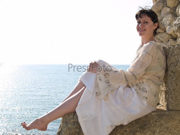 Young Smiling Lady Sitting on Stone Relaxed Looking to Camera