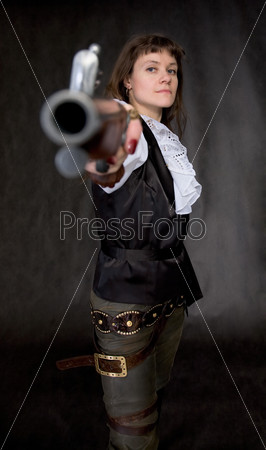 The girl - pirate with ancient pistol in hand on a black background