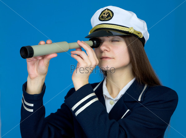 Portrait of the woman - captain with telescope on a blue background