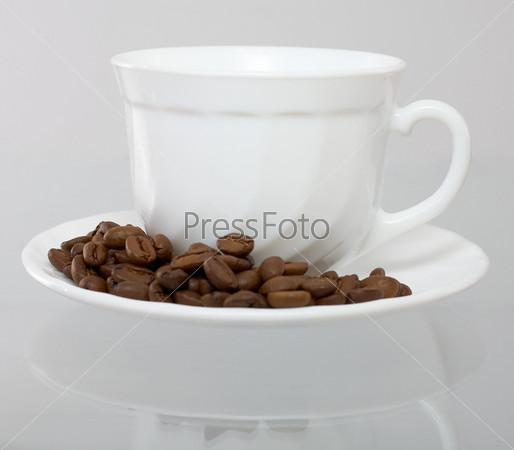 Cup and saucer with grain coffee costing on glass