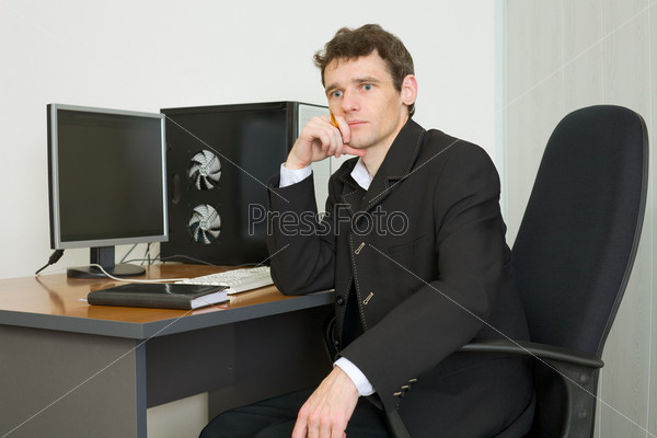 The young businessman sits at a table at office