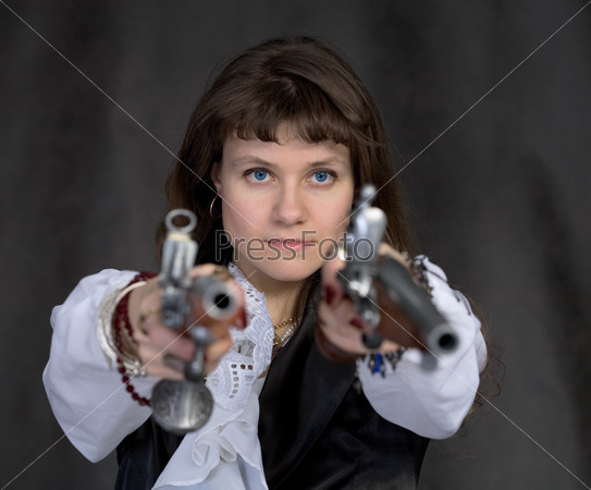 The girl - pirate with two ancient pistols in hands on a black