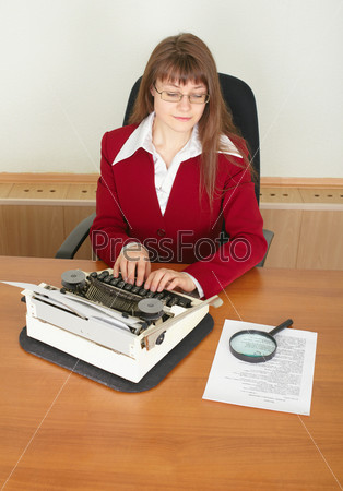 The serious woman the secretary printing the text on an ancient typewriter