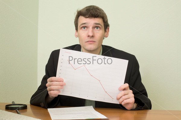 The clerk at office sits at a desktop with financial graph