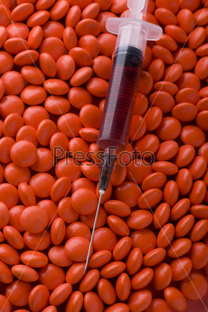 object on red - Medical Tablets and syringe close up