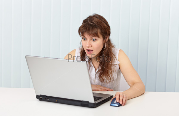 Indignant woman works in Internet with laptop