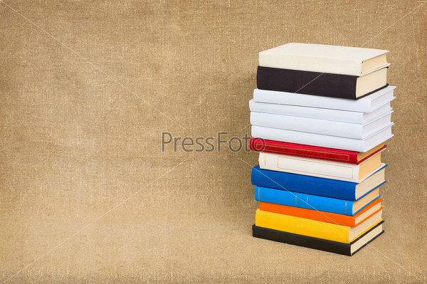 Pyramid from books with color covers on a canvas