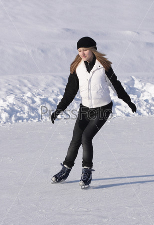 girl sliding on winter skates at the rink