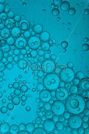 blue colored liquid with bubbles of oil
