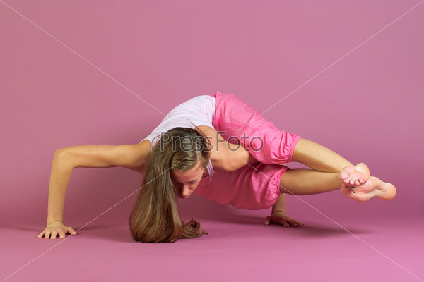 Young beautiful woman in pink practice yoga