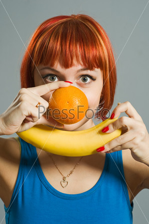 Red-haired girl with banana and orange