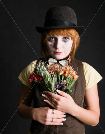 Sad clown with bouquet