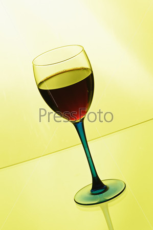 Wineglass with red wine  on yellow background