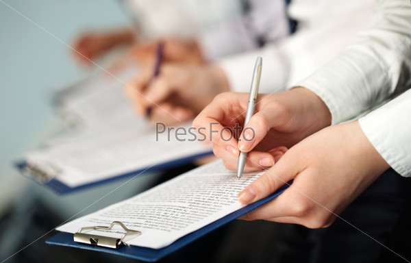 Row of hands of business people holding documents and pens