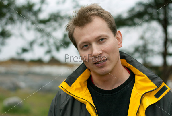 Man in jacket with yellow collar smiles