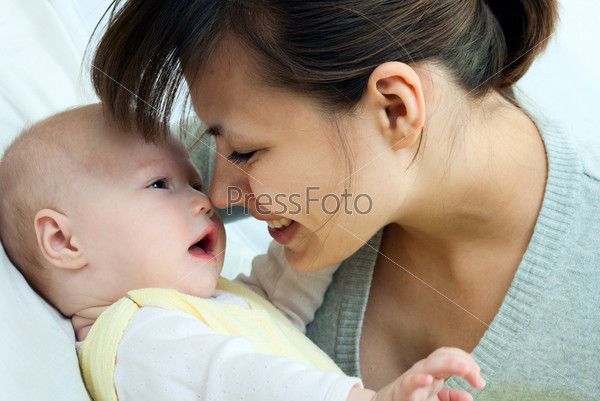 happy family: mother and baby - playing and smiling