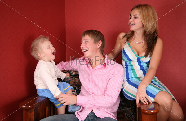 young family laughing in red room