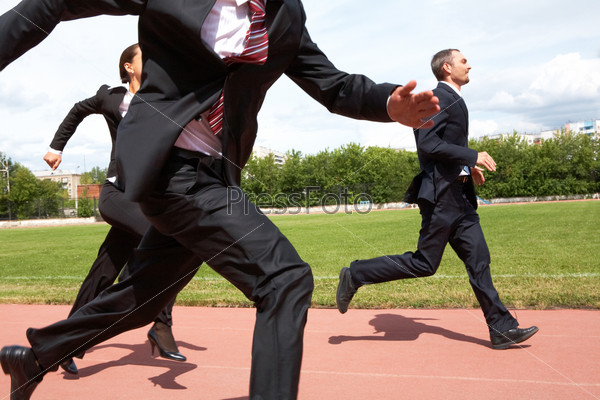Photo of energetic business people in suits running