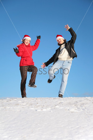 couple dance on  snow hill in santa claus hats