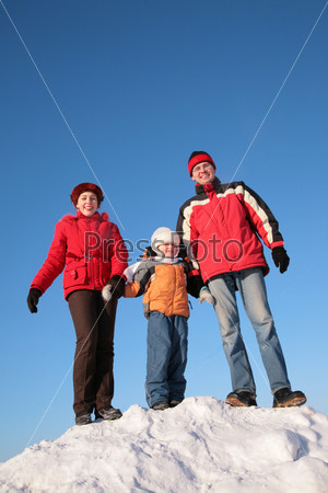 parents with son on the top of snowy hill