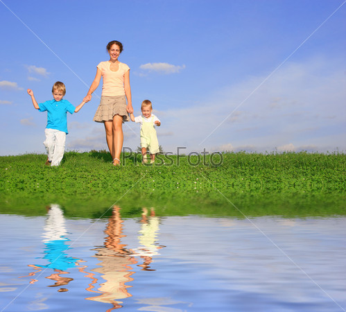 mother with children on meadow and water