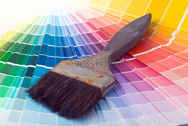 A paint brush over a wheel of colorful paint swatches.
