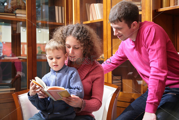 parents read book with son