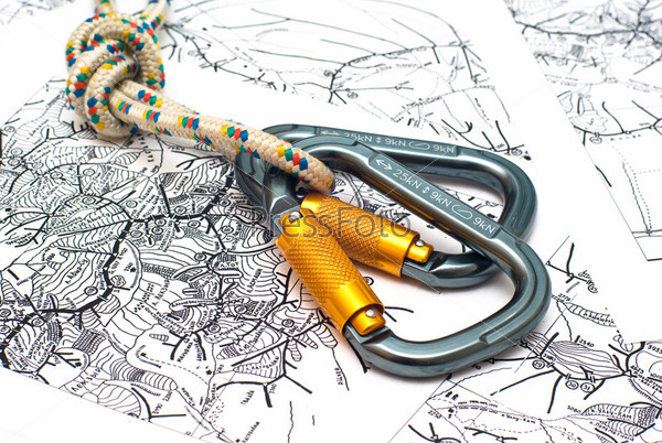 two alpinism carabiners and rope on a map background