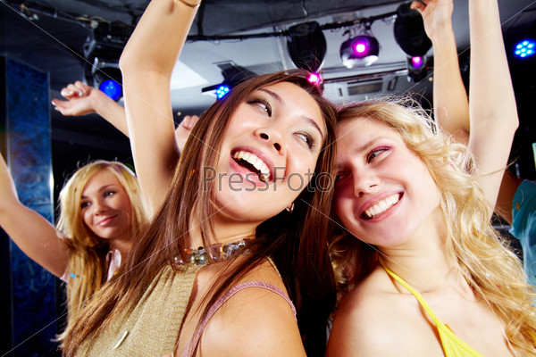 Two joyful girls dancing in night club and having fun, stock photo