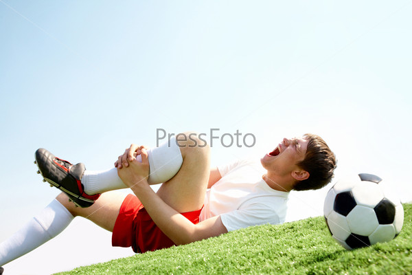 Image of soccer player lying down and shouting in pain