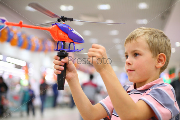 Boy in shop with toy helicopter