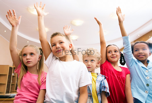 Image of pupils raising arms during the lesson , stock photo