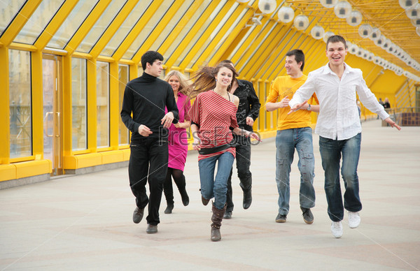 group of friends runs on footbridge