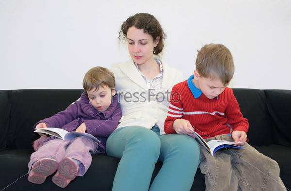 children with mother read books on sofa