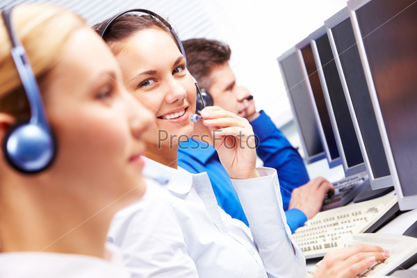 Smart operator sitting between co-workers during telephone conversation