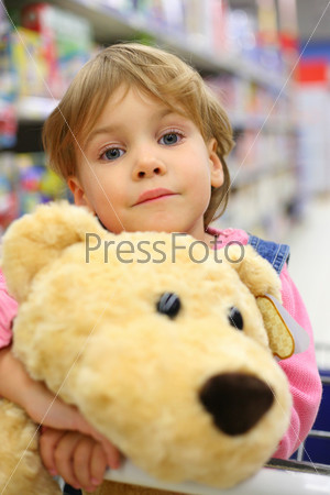 Girl with soft toy in shop