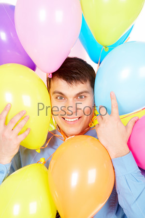 Image of successful businessman face surrounded by multicolored balloons