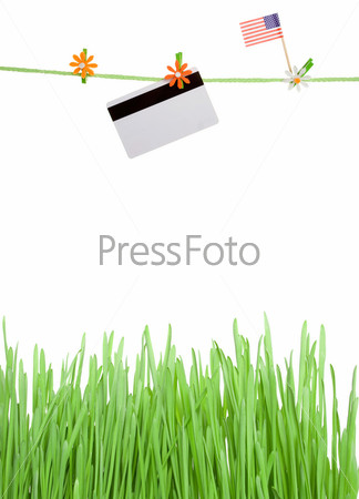 Concept. Lawn grass over it on a rope hanging a plastic card and an USA flag