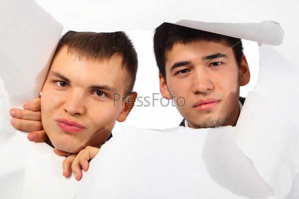 Two young men looking out in hole in paper